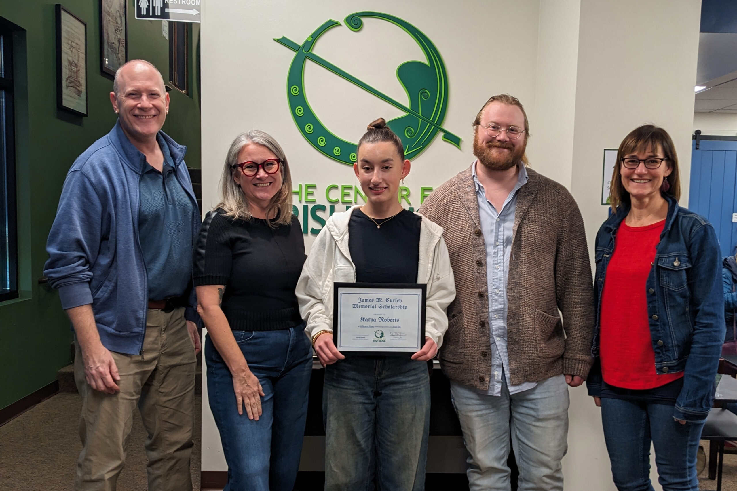 Katya Roberts standing with (from left to right): Dennis Curley, Kate Wade, Ryan Behnke, and Norah Rendell.